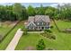 Aerial view of a stately home with a long driveway, expansive lawn, and beautiful landscaping at 107 Equest Dr, Canton, GA 30115