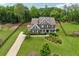 Aerial view of a well-maintained home with lush landscaping, a long driveway, and expansive green lawns at 107 Equest Dr, Canton, GA 30115