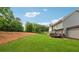 Large backyard featuring lush lawn, a wooden deck, and mature trees creating a serene outdoor space at 107 Equest Dr, Canton, GA 30115