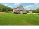 Home exterior featuring a spacious, well-manicured lawn with a deck and lush green trees at 107 Equest Dr, Canton, GA 30115