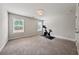 Bonus room with exercise bike, carpet, two windows and neutral wall color at 107 Equest Dr, Canton, GA 30115