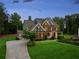 This exterior elevation displays a spacious home with a large front yard, and a paved driveway at 107 Equest Dr, Canton, GA 30115