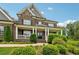 Lovely brick home with a covered front porch, white columns, and manicured shrubs at 107 Equest Dr, Canton, GA 30115