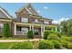 Stately brick home featuring a welcoming front porch and manicured shrubbery at 107 Equest Dr, Canton, GA 30115