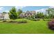 Beautiful home with a lush green lawn, mature trees, and manicured landscaping at 107 Equest Dr, Canton, GA 30115