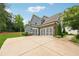 Attached three-car garage with a large concrete driveway and well-maintained landscaping at 107 Equest Dr, Canton, GA 30115