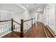 Hallway with hardwood flooring, white trim, and a view of the staircase and upstairs landing at 107 Equest Dr, Canton, GA 30115