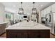 Open-concept kitchen with stainless steel appliances, a large island with bar seating, and a view into the living area at 107 Equest Dr, Canton, GA 30115