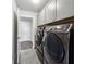 Gray laundry room with washer, dryer and upper storage cabinets at 107 Equest Dr, Canton, GA 30115