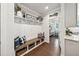 Charming mudroom featuring custom built-in storage, a bench, hooks, and easy access to the kitchen and pantry at 107 Equest Dr, Canton, GA 30115