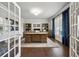Bright home office with French doors, wooden desk, and large window with curtains at 107 Equest Dr, Canton, GA 30115