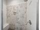 Shower showcasing decorative grey and white tiled walls, rain shower head, and shower seat at 107 Equest Dr, Canton, GA 30115