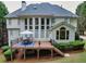 Home's rear exterior featuring a spacious deck with a dining set and large windows at 1564 Stepstone Way, Lawrenceville, GA 30043