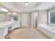 Bright bathroom featuring a large tub, dual vanities, and neutral finishes at 1564 Stepstone Way, Lawrenceville, GA 30043