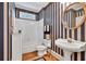 Charming bathroom with striped wallpaper, soaking tub, white vanity, and decorative round mirror at 1564 Stepstone Way, Lawrenceville, GA 30043