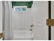 White bathroom featuring a shower and tub combo with a window, complemented by emerald green wallpaper at 1564 Stepstone Way, Lawrenceville, GA 30043