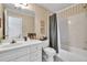 Well-lit bathroom with white vanity, toilet, and tub/shower, accentuated by striped wallpaper at 1564 Stepstone Way, Lawrenceville, GA 30043