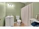 This well-lit bathroom has a single vanity, toilet, and shower with a curtain at 1564 Stepstone Way, Lawrenceville, GA 30043