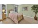 Cozy bedroom with striped bedding, side table, and a decorative plant near the window at 1564 Stepstone Way, Lawrenceville, GA 30043