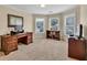 Comfortable home office with wood furniture, neutral walls, bright windows, and carpeted floors at 1564 Stepstone Way, Lawrenceville, GA 30043