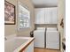 Practical laundry room with sink, washer, dryer, and ample storage space at 1564 Stepstone Way, Lawrenceville, GA 30043