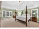 Spacious main bedroom with a four poster bed, tray ceilings, and large windows at 1564 Stepstone Way, Lawrenceville, GA 30043