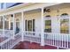 Inviting front porch with white columns, ceiling fans, rocking chairs and decorative windows at 1650 Old Loganville Rd, Loganville, GA 30052