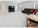Bright living room with neutral walls, plush carpet, and a comfortable leather sofa at 258 Dawson Dr, Woodstock, GA 30188