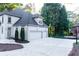 Side view of a large home with a three-car garage and basketball court, surrounded by trees at 3258 Bransley Way, Duluth, GA 30097