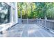 Spacious stone patio with gray railing and view of the wooded backyard at 3258 Bransley Way, Duluth, GA 30097