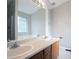 Bright bathroom featuring double sinks, a large mirror, and vanity with wood-stained cabinets at 3617 Summit Trce, Decatur, GA 30034