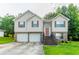 Two-story home featuring a two-car garage, tan siding, brick accents, and a well-manicured front lawn at 3617 Summit Trce, Decatur, GA 30034