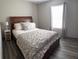 Bedroom featuring a large bed, modern laminate flooring, and a bright window for a relaxing retreat at 4678 Browns Mill Ferry Rd, Lithonia, GA 30038
