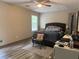 Bedroom featuring modern laminate flooring, a large window, and a ceiling fan for comfort at 4678 Browns Mill Ferry Rd, Lithonia, GA 30038