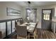 Inviting dining area featuring a modern light fixture, stylish wainscoting, and a view to the backyard at 4678 Browns Mill Ferry Rd, Lithonia, GA 30038