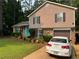 Inviting split-level home with tidy lawn, charming shutters, and a paved driveway leading to an attached garage at 4678 Browns Mill Ferry Rd, Lithonia, GA 30038
