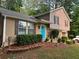 Charming split-level home featuring manicured shrubs, a bright front door, and a blend of siding and brick at 4678 Browns Mill Ferry Rd, Lithonia, GA 30038