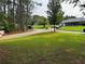 Spacious front yard with mature trees, a long driveway, and glimpses of neighboring homes at 4678 Browns Mill Ferry Rd, Lithonia, GA 30038