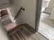 This hallway has hardwood floors and a staircase leading to the bathroom with modern tile flooring at 4678 Browns Mill Ferry Rd, Lithonia, GA 30038