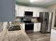 Well-lit kitchen featuring stainless steel appliances, granite countertops, and white cabinets for a modern look at 4678 Browns Mill Ferry Rd, Lithonia, GA 30038