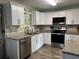 Modern kitchen featuring stainless steel appliances, granite countertops, white cabinets and stylish backsplash at 4678 Browns Mill Ferry Rd, Lithonia, GA 30038