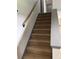 Carpeted staircase with wood railing and painted trim, providing a functional and stylish transition between floors at 4678 Browns Mill Ferry Rd, Lithonia, GA 30038