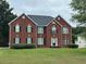 Charming two-story red brick home with a well-manicured front lawn and classic architectural details at 10175 Hemlock Way, Jonesboro, GA 30238