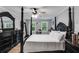 Stylish main bedroom featuring a four-poster bed, elegant furnishings, and ample natural light at 212 Teepee Trl, Whitesburg, GA 30185