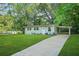 Well-manicured lawn and lush landscaping leading to a quaint home with carport at 390 Lincoln Sw Pl, Atlanta, GA 30315