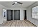 Bright bedroom featuring a ceiling fan, modern flooring and black closet doors at 4756 Fellsridge Dr, Stone Mountain, GA 30083