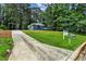 Home's curb appeal with a manicured lawn, mature trees, and a 