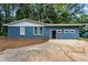 Charming blue brick home featuring a two-car garage with modern garage doors at 4756 Fellsridge Dr, Stone Mountain, GA 30083