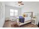 Bright bedroom features neutral walls, hardwood flooring, a ceiling fan, and plenty of natural light at 5310 Chestnut Dr, Cumming, GA 30040