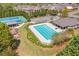 Aerial view of a community pool and tennis courts nestled among trees at 5310 Chestnut Dr, Cumming, GA 30040